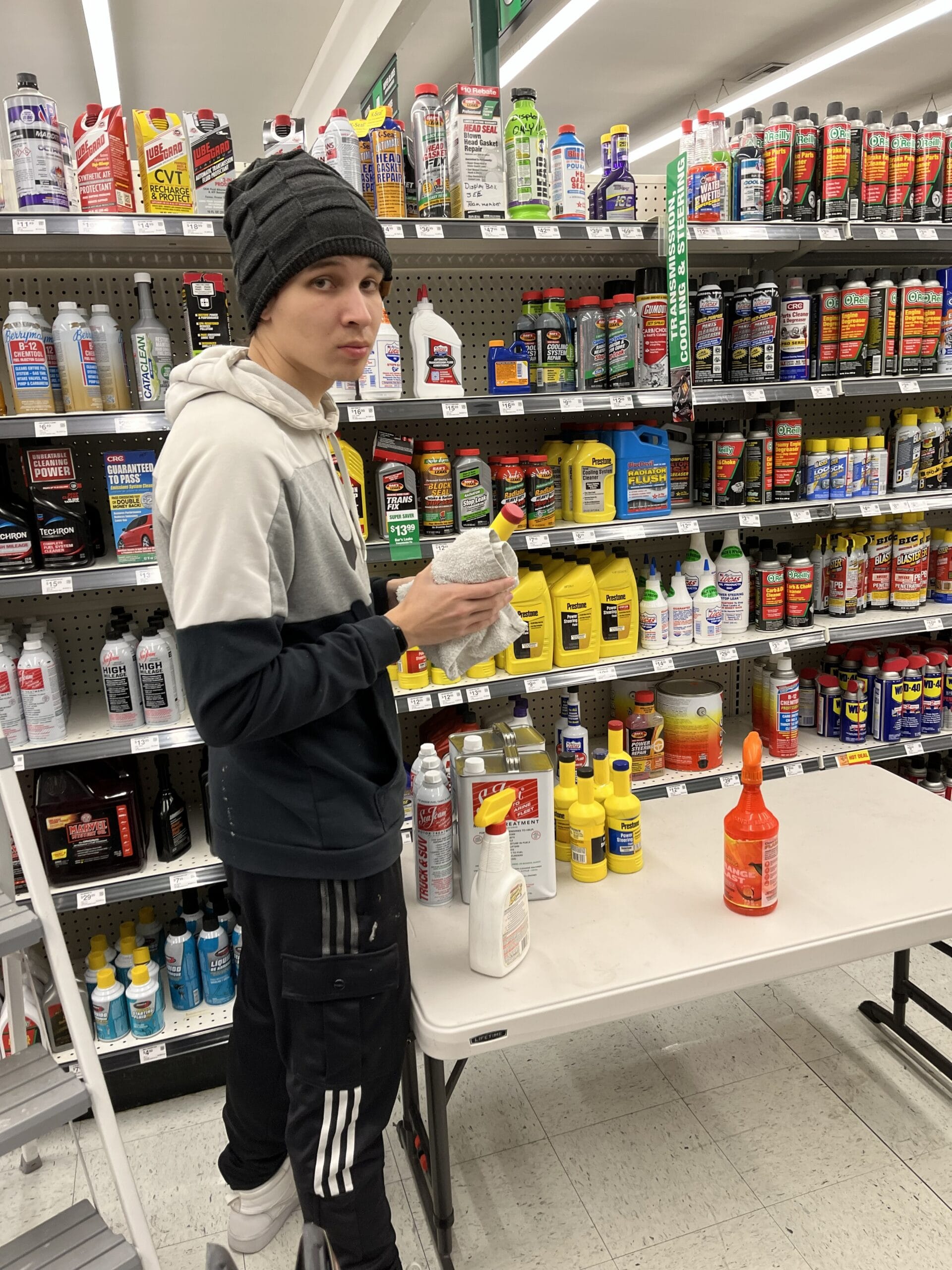 Commercial cleaning technician working on retail store shelving