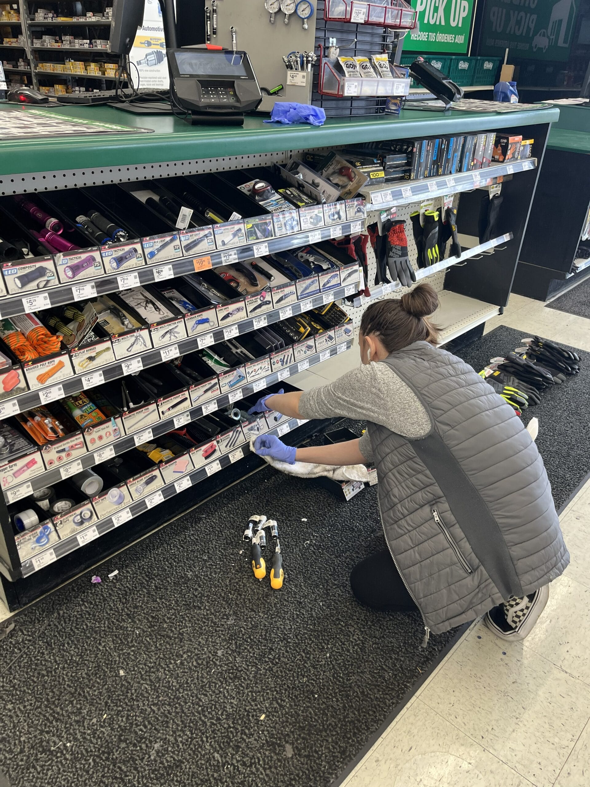 Commercial cleaner detailing lower checkout shelving and fixtures